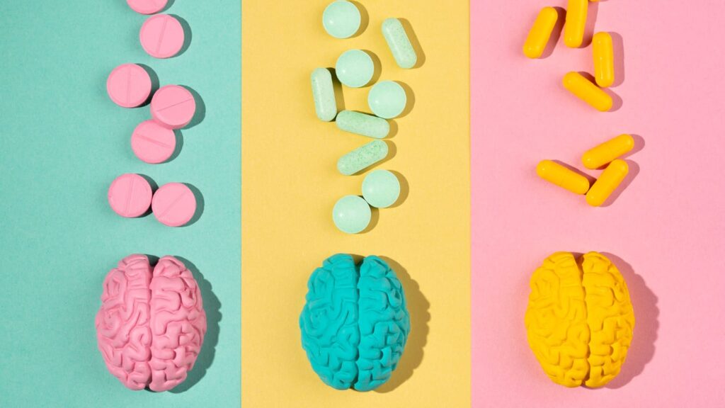 Drie hersenmodellen met bijpassende pillen in felle kleuren, visueel gekoppeld aan kleurenpsychologie.
