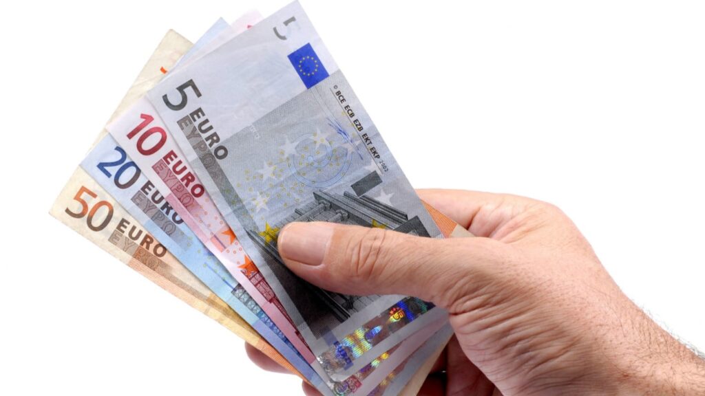 Hand houdt meerdere eurobiljetten vast als symbool voor toeslag aanvragen