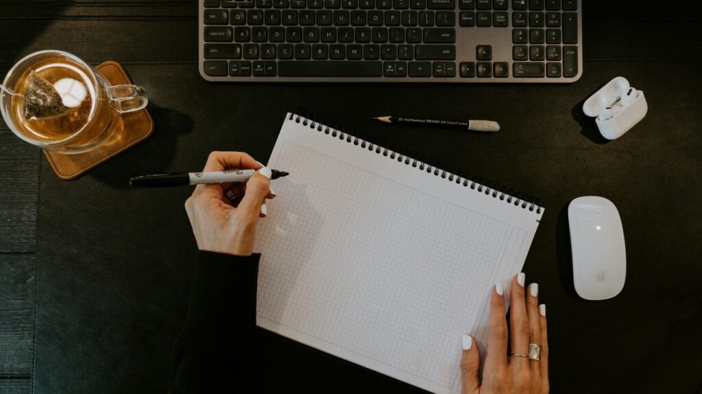 Persoon schrijft takenlijst om taken te structureren en prioriteiten te bepalen