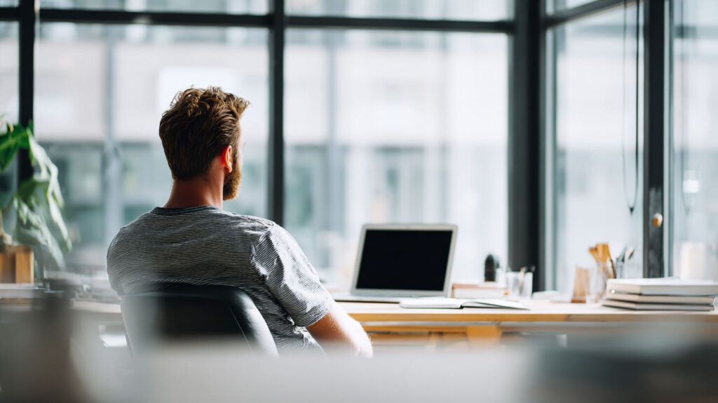 Medewerker aan opgeruimd bureau in een rustige kantooromgeving met een werkplek overzichtelijker ingericht