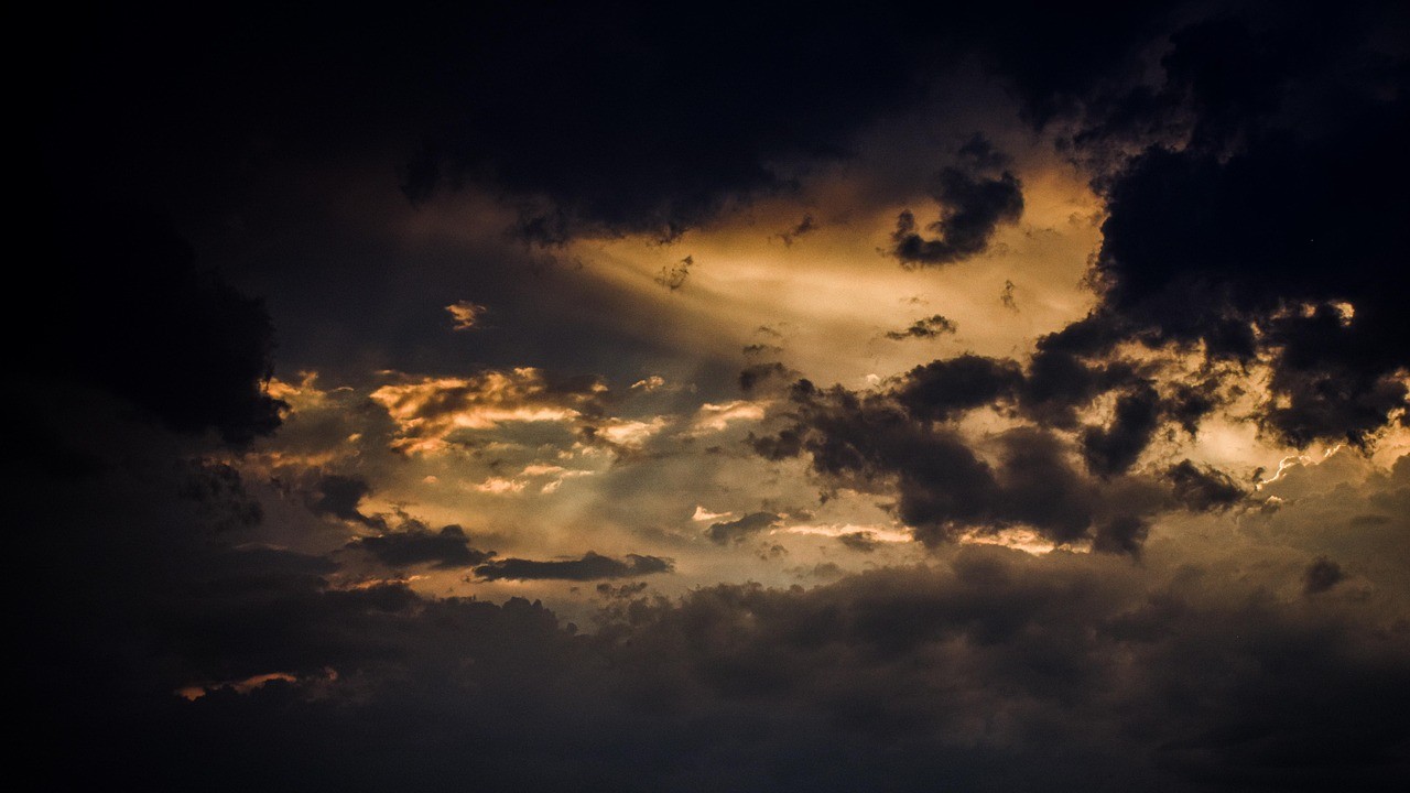 Donkere stormlucht met zonnestralen door de wolken – na zo'n storm is het belangrijk je dak te controleren